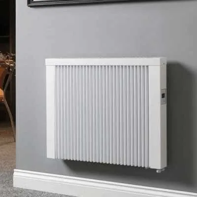 White electric radiator with a ribbed front on a grey wall